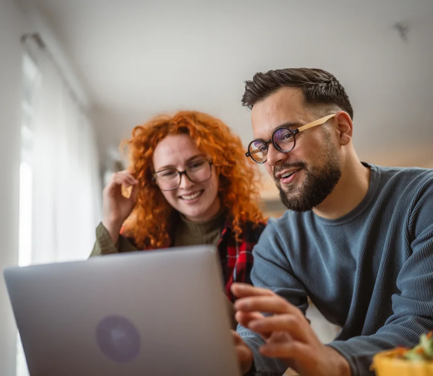 Eine Frau und ein Mann sitzen vor einem Laptop